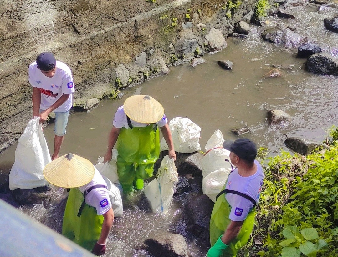 Warga Desa Tateli yang menelusuri Sungai dan mengangkat sampah-sampah, Selasa (12/12).