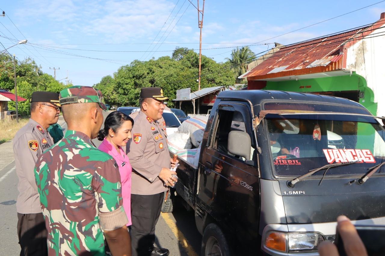Kapolres Bolaang Utara (Bolmut) AKBP Juleigtin Siahaan membagikan takjil kepada masyarakat yang lewat di Jalan Trans Sulawesi Desa Boroko, Selasa (19/03/2024).