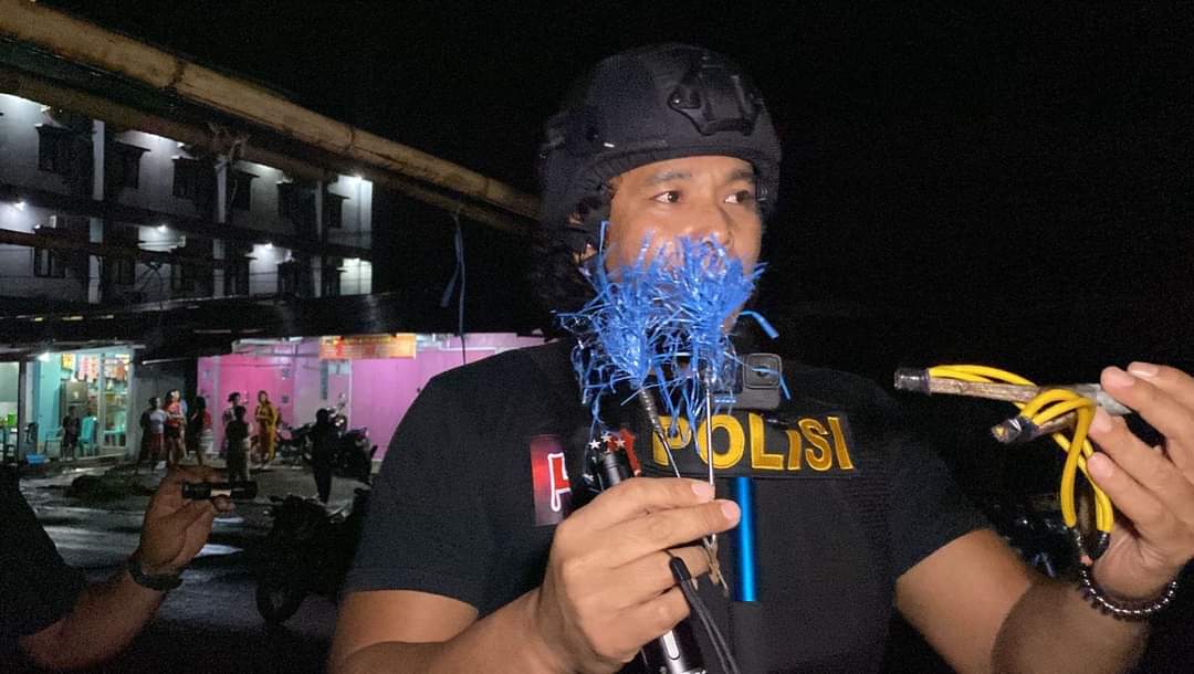 Katim Tarsius Presisi Polres Bitung Bripka Angky Koagow memegang barang bukti senjata tajam jenis panah wayer yang berhasil diamankan.(Dok Istimewa)