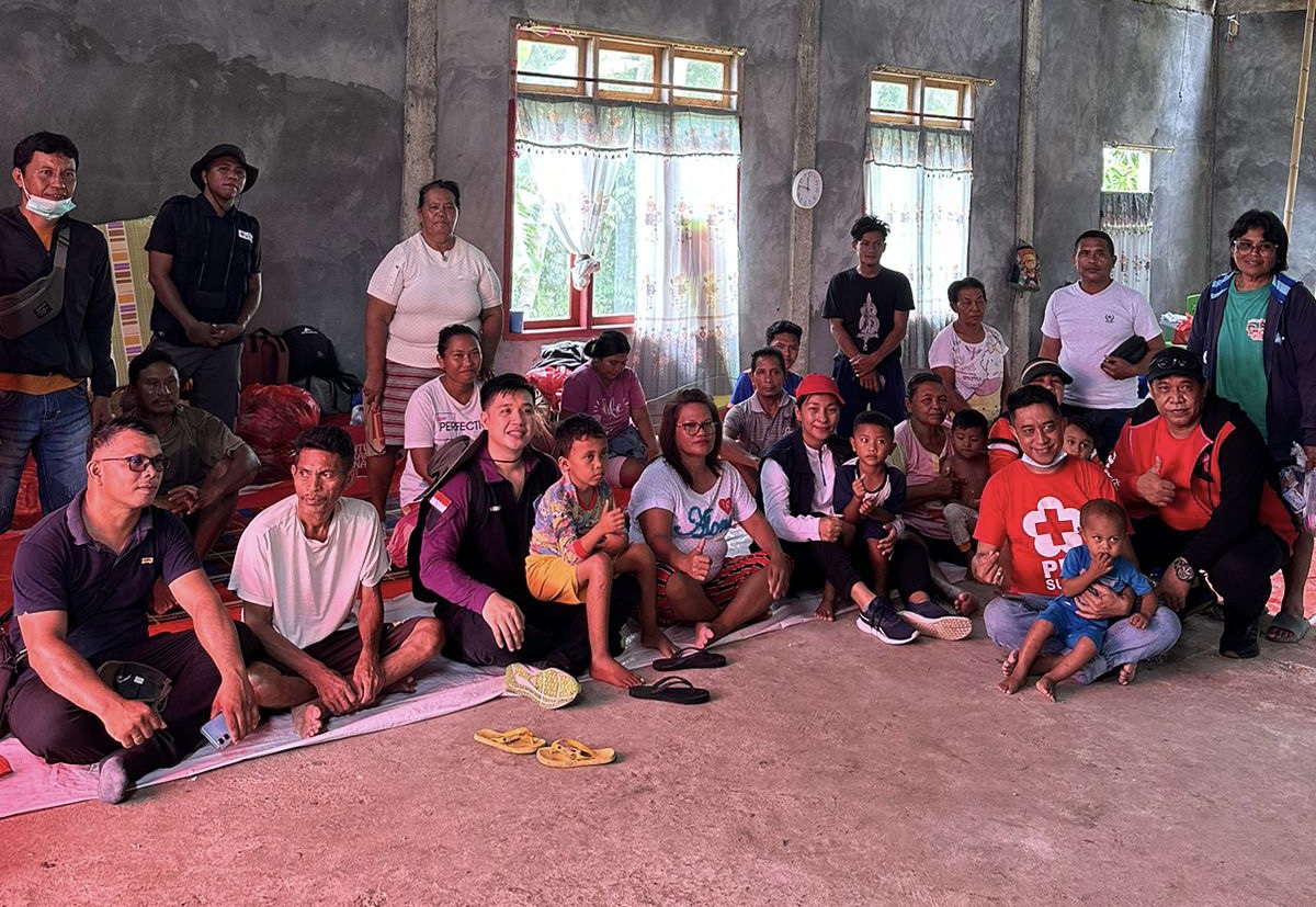Pengurus dan anggota PMI Sitaro bersama warga terdampak letusan Gunung Api Ruang di lokasi pengungsian di Tagulandang. (Istimewa)