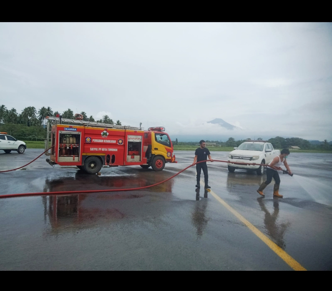 SIGAP: Tim Damkar Pemkot Tomohon saat membersihkan area di Bandara Internasional Sam Ratulangi Manado, imbas terdampak abu vulkanik Gunung Ruang. Dok istimewa