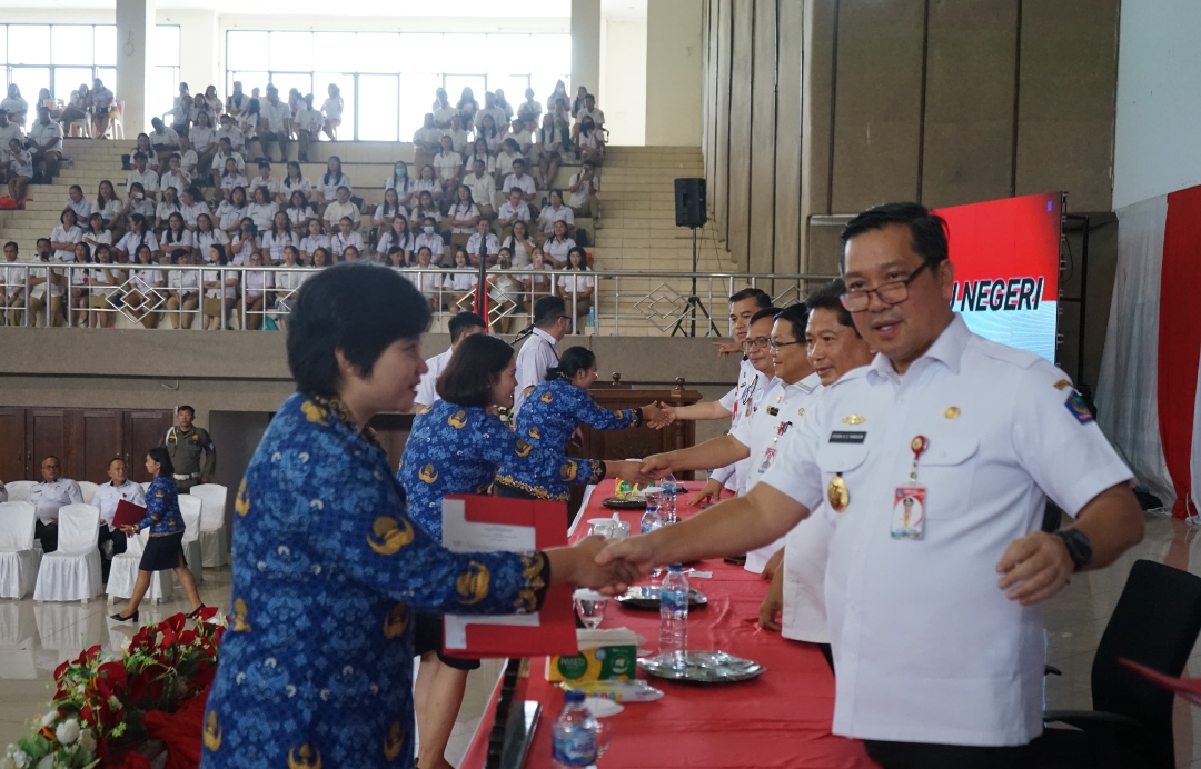 SERAHKAN: Wagub Sulut Steven Kandouw menyerahkan SK kepada salah satu PNS di Kabupaten Minahasa, Rabu (5/6/2024).