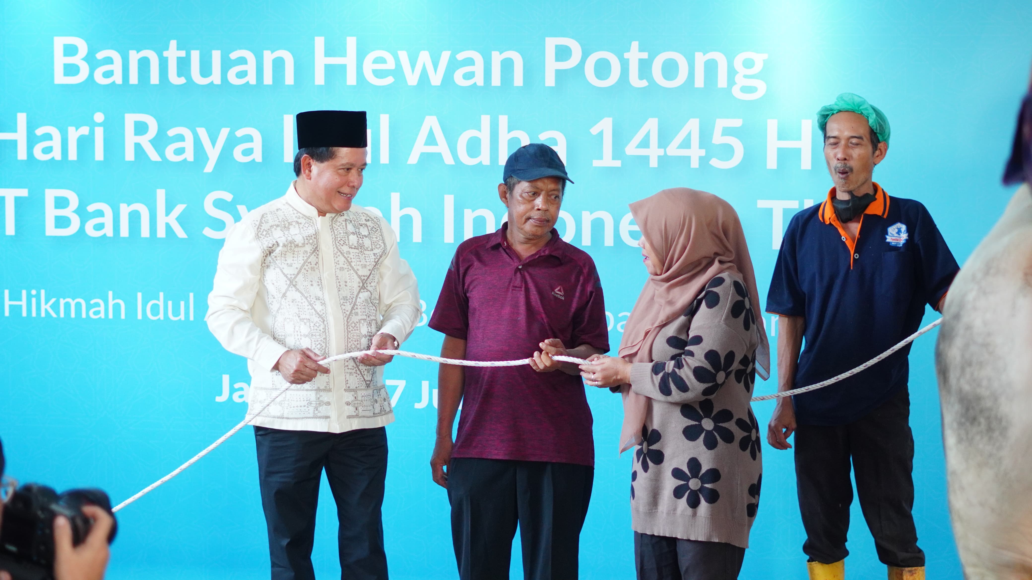 Direktur Utama BSI Hery Gunardi (kiri) menyerahkan secara simbolik hewan potong kepada duafa di Jakarta, Senin (17/6).