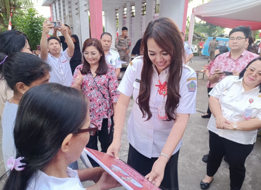 Sekretaris TP-PKK Sulut dr Kartika Devi Kandouw Tanos bersama masyarakat penerima bantuan di kantor kelurahan Bailang, kecamatan Bunaken, kemarin.