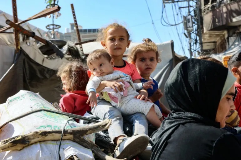 Anak-anak Palestina mengungsi dari Kota Gaza di Jalur Utara pada hari Sabtu (12/10) (Omar al-Qattaa/AFP)