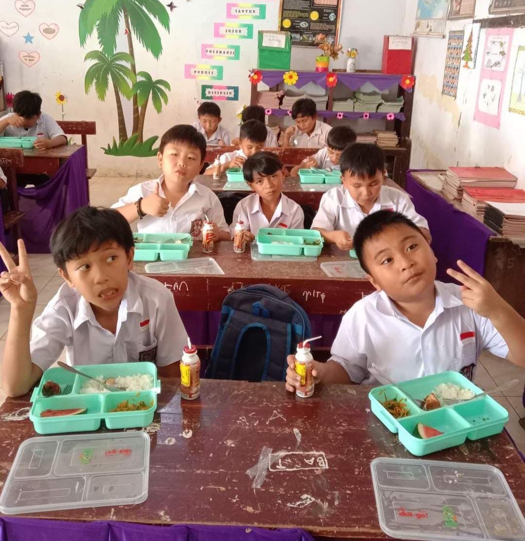 Tampak para siswa saat makan siang gratis di SD Katolik Santa Monica Langowan, Rabu (23/10/2024).