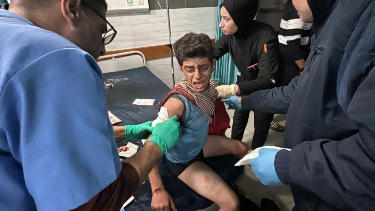 Petugas medis di Rumah Sakit Kamal Adwan membantu seorang anak Palestina yang terluka di Beit Lahiya, Gaza utara, pada 17 Desember 2024 (Reuters)