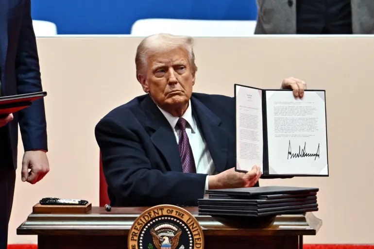 Presiden AS Donald Trump menandatangani perintah eksekutif selama parade pelantikan di Capital One Arena, di Washington, DC, pada 20 Januari 2025. (Angela Weiss/AFP)