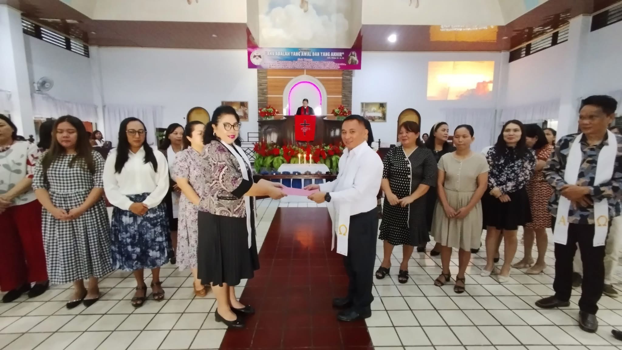 Ketua Panitia H2RG GMIM Imanuel Kamangta Pnt Erwin Worotikan SST Ak, menerima SK dari BPMJ yang diserahkan Sekretaris Jemaat Pnt Ir Erny Molenaar-Nurali MS, Minggu (26/01/2025).