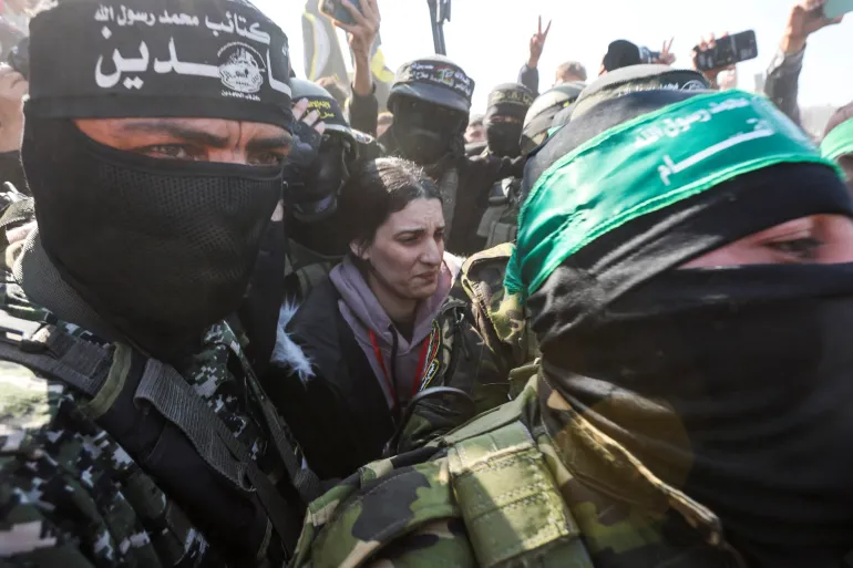 Pasukan keamanan Palestina mengepung tawanan Israel Arbel Yehud saat mereka menyerahkannya kepada anggota Palang Merah, di Khan Younis, Gaza selatan, 30 Januari 2025 (Ramadhan Abed/Reuters)