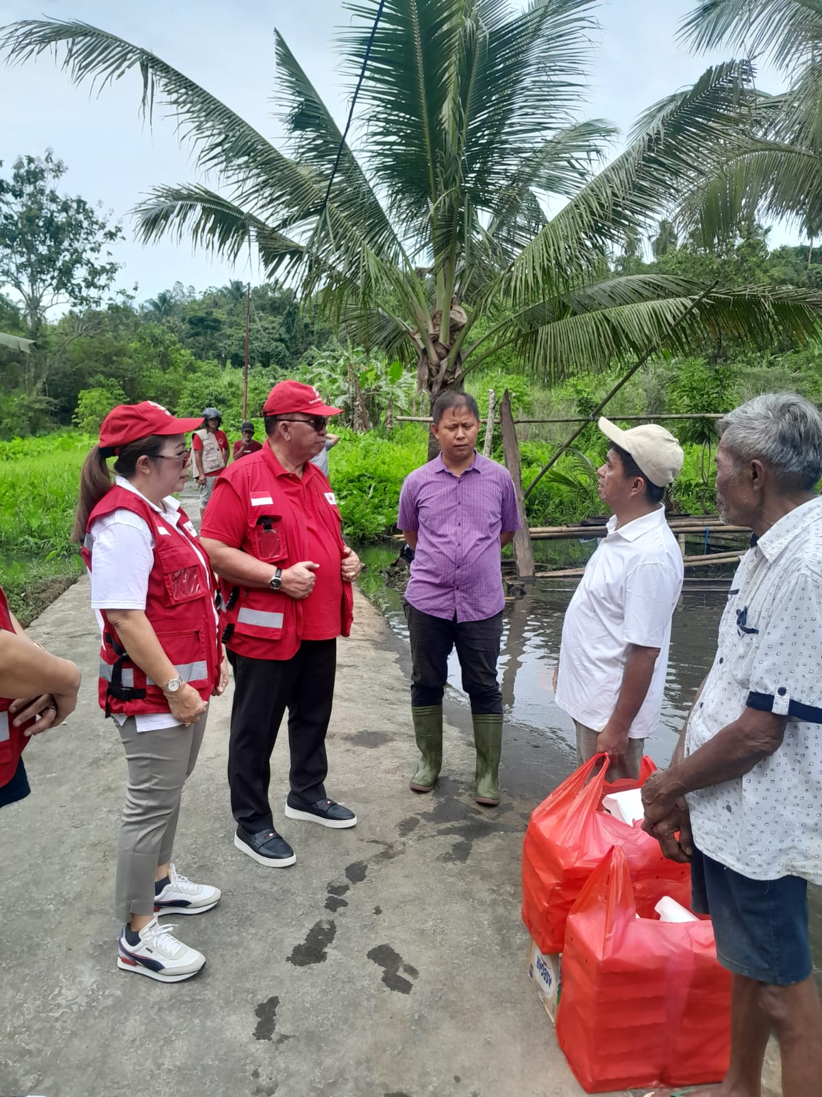 SALURKAN BANTUAN: Bupati dan Ketua TP PKK bersama PMI salur bantuan makanan di Malendeng yang masuk wilayah Kabupaten Minahasa, Minggu (23/3/2025).