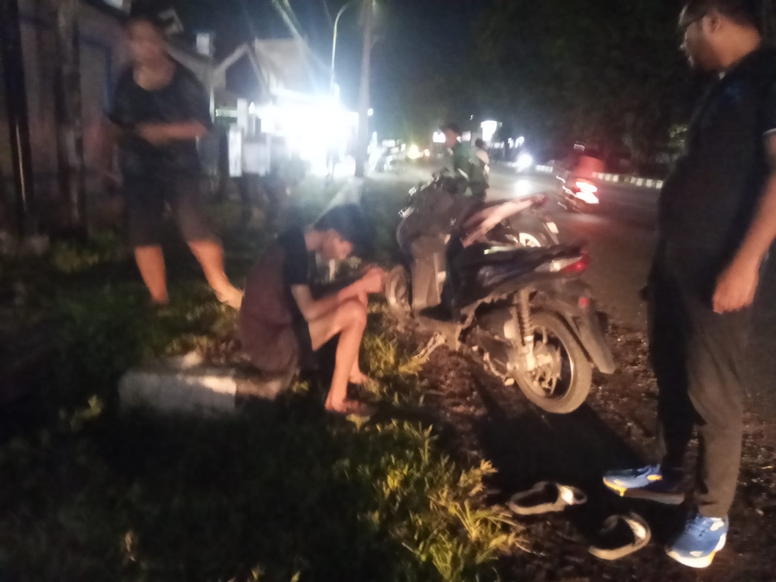 Nampak pengendara bersama sepeda motornya setelah dievakuasi ke pinggir jalan pasca insiden.(Franky Sumaraw/MP)