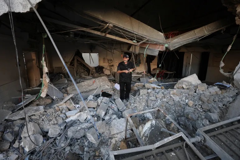 Warga Palestina memeriksa Rumah Sakit Arab al-Ahli [Dawoud Abu Alkas/Reuters]