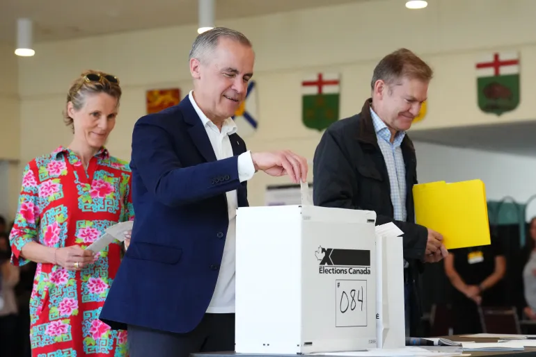 Perdana Menteri Kanada dan pemimpin Partai Liberal Mark Carney, bersama istrinya Diana Fox Carney, memberikan suaranya di Ottawa, Kanada, pada hari Senin (28/4) (Sean Kilpatrick/Pool/AFP)