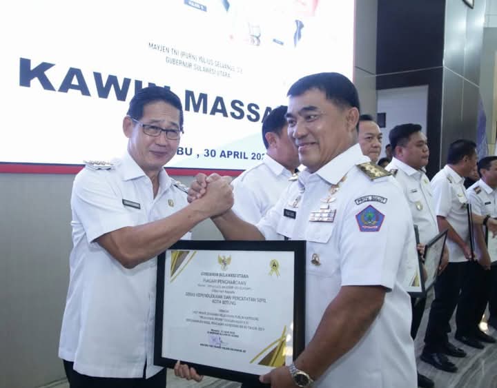Gubernur Sulut Mayjen TNI (Purn) Yulius Selvanus saat menyerahkan penghargaan kepada Wali Kota Bitung Hengky Honandar.(Dok Istimewa)