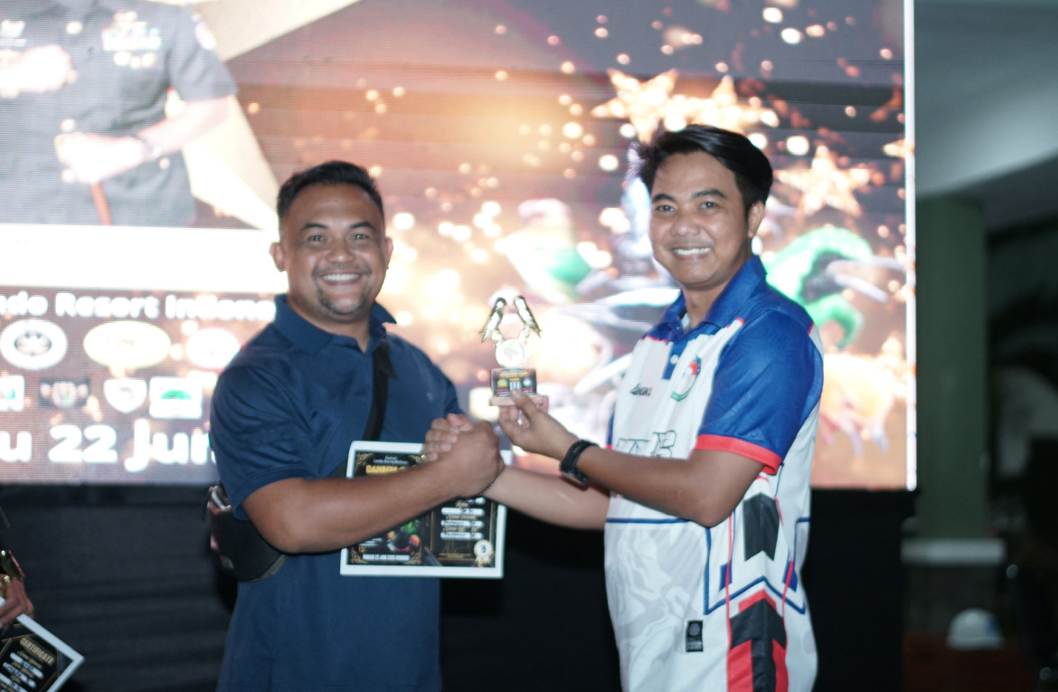 Asisten Dewan Direksi PT Eresindo Resort Indonesia Rizky (kaos putih biru) menyerahkan trophy kepada salah satu pemenang Festival Lomba Burung Berkicau Danrem Cup 2025