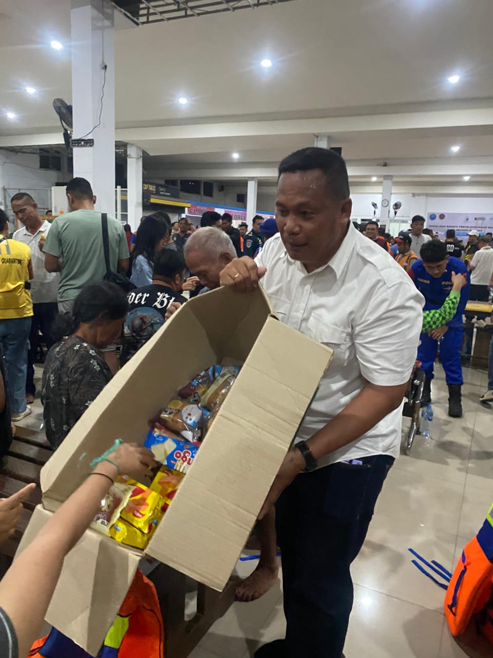 Anggota DPRD Kabupaten Kepulauan Talaud dari Partai Gerindra Muhamad Sarifudin Kofia saat membantu para penumpang KM Barcelona V di pelabuhan Manado yang berhasil di evakuasi.