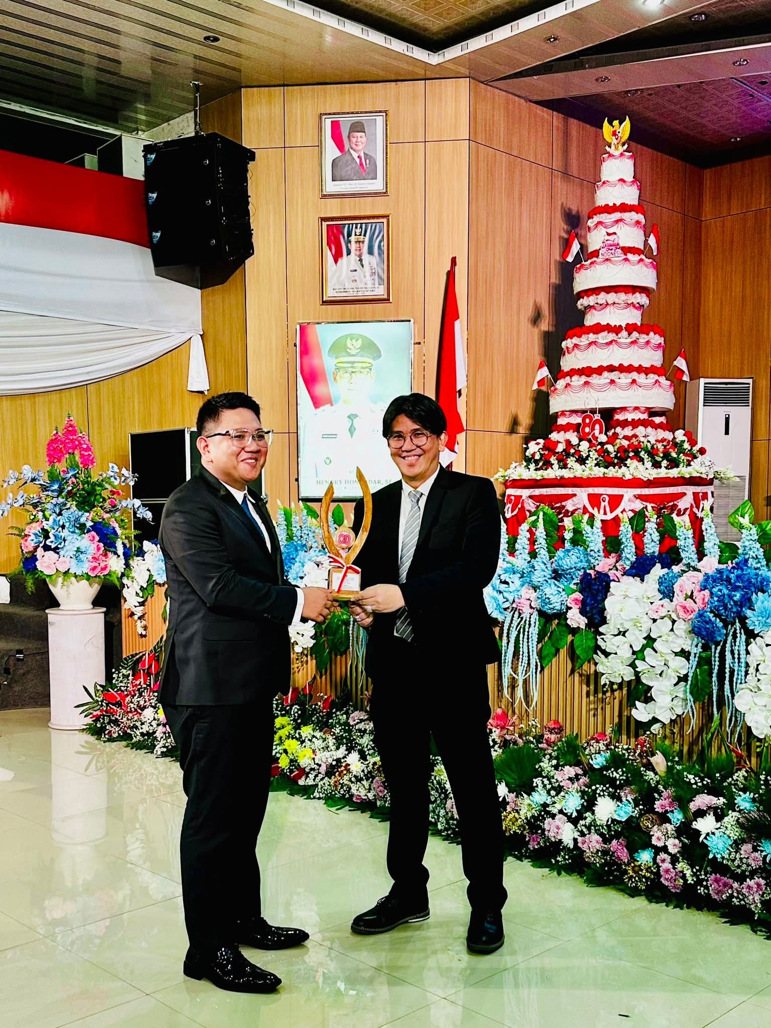 Wakil Wali Kota Bitung Randito Maringka menyerahkan trofi juara 1 lomba gerak jalan kepada Kepala Dinas PUTR Rizal Sompotan.(Dok Istimewa)