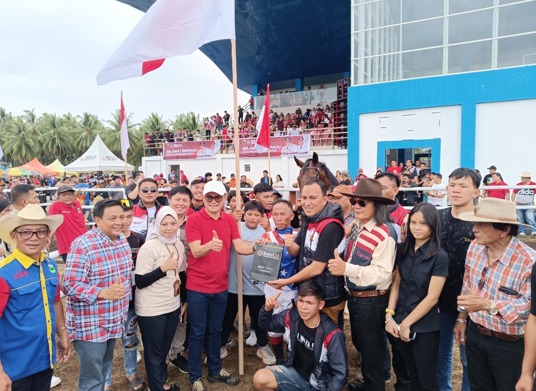 Bupati Minahasa Utara Joune Ganda menyerahkan cinderamata emas batang dari Galeri 24 ke pemenang pertama kejuaraan pacuan kuda