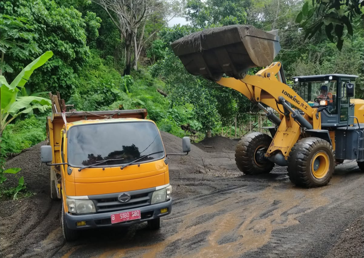 Satu unit alat berat dikerahkan untuk membersihkan material pasir ruas jalan di wilayah Kelurahan Kadoodan.(Dok Istimewa)
