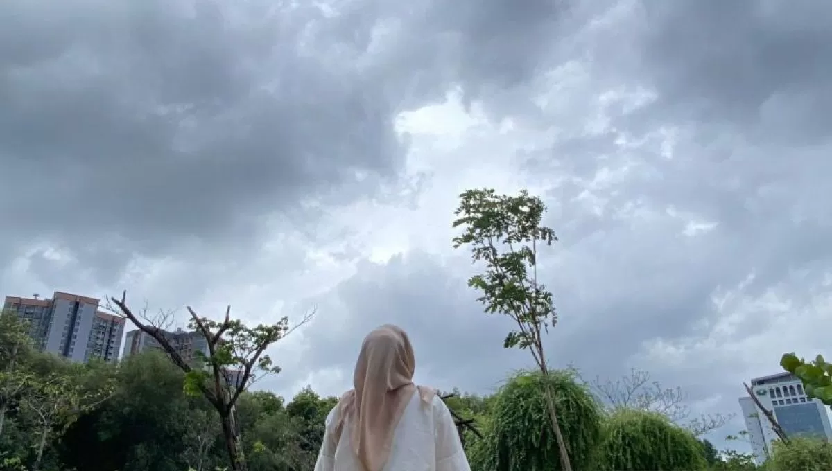 Seorang warga mengamati gumpalan awan tebal dan pekat di langit Jakarta Utara (M Riezko Bima Elko Prasetyo/ANTARA)