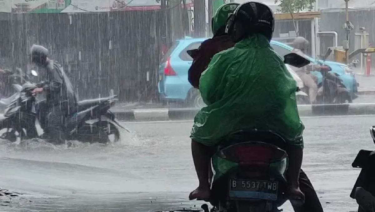 Pengendara motor menerobos genangan air saat hujan di Jalan Raya Pasar Minggu, Jakarta, Jumat (22/11/2024) (M Riezko Bima Elko Prasetyo/ANTARA)