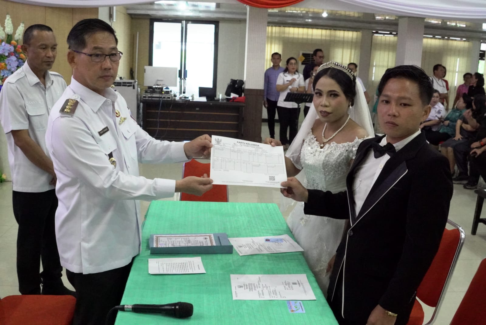 Wali Kota Bitung Hengky Honandar menyerahkan akta nikah dalam kegiatan kawin massal.(Dok Istimewa)