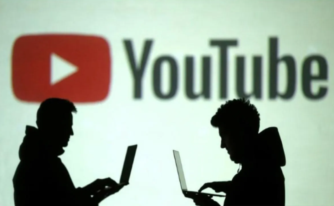 Siluet pengguna perangkat elektronik dengan latar logo YouTube. (REUTERS/Dado Ruvic)