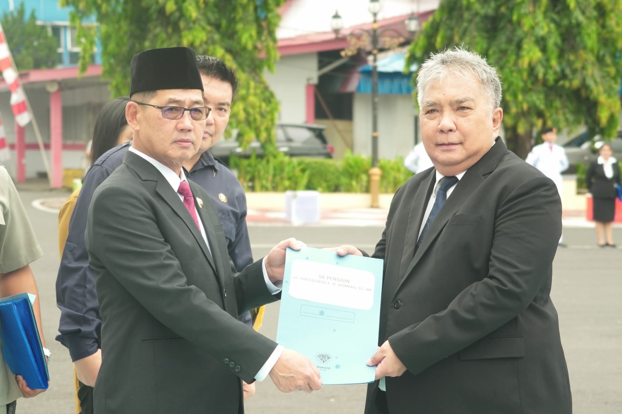 Wali Kota Bitung Hengky Honandar menyerahkan SK pensiun kepada Kepala Dinas Kominfo Theodorus Rompas.(Dok Istimewa)