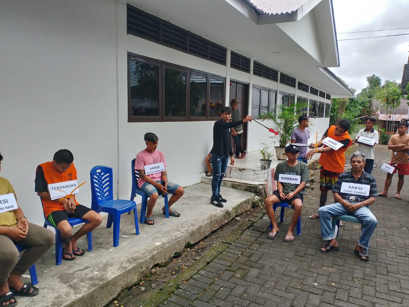Rekonstruksi-Terlihat salah satu pelaku saat melakukan pembacokan kepada korban di area kepala dalam rekonstruksi ulang personil Polsek Dimembe