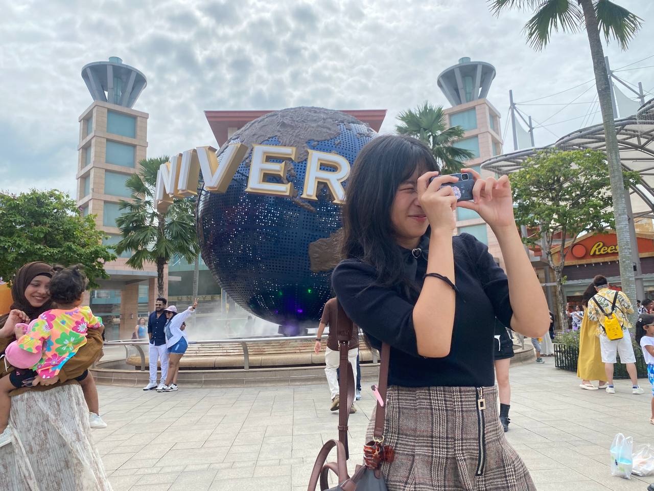 Xanelle Supit mengabadikan momen liburannya di Universal Studios Singapore saat perjalanan Xpresi Party 2025 sebagai hadiah kemenangannya, dengan ceria berpose di depan ikon globe USS.