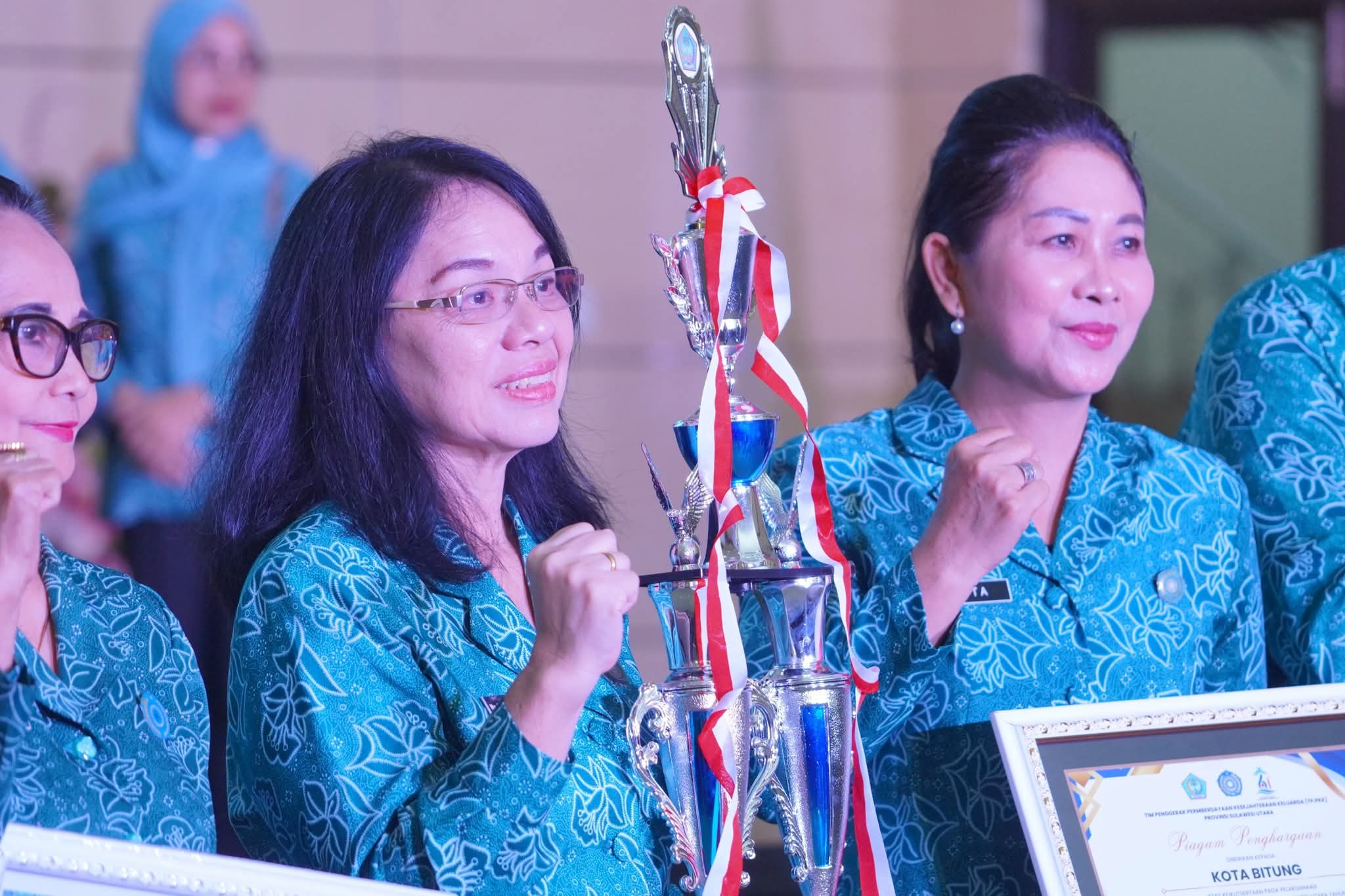 Ketua TP-PKK Provinsi Sulut Anik Yulius Selvanus menyerahkan piala kepada Ketua TP-PKK Kota Bitung Ellen Honandar Sondakh.(Dok Istimewa)
