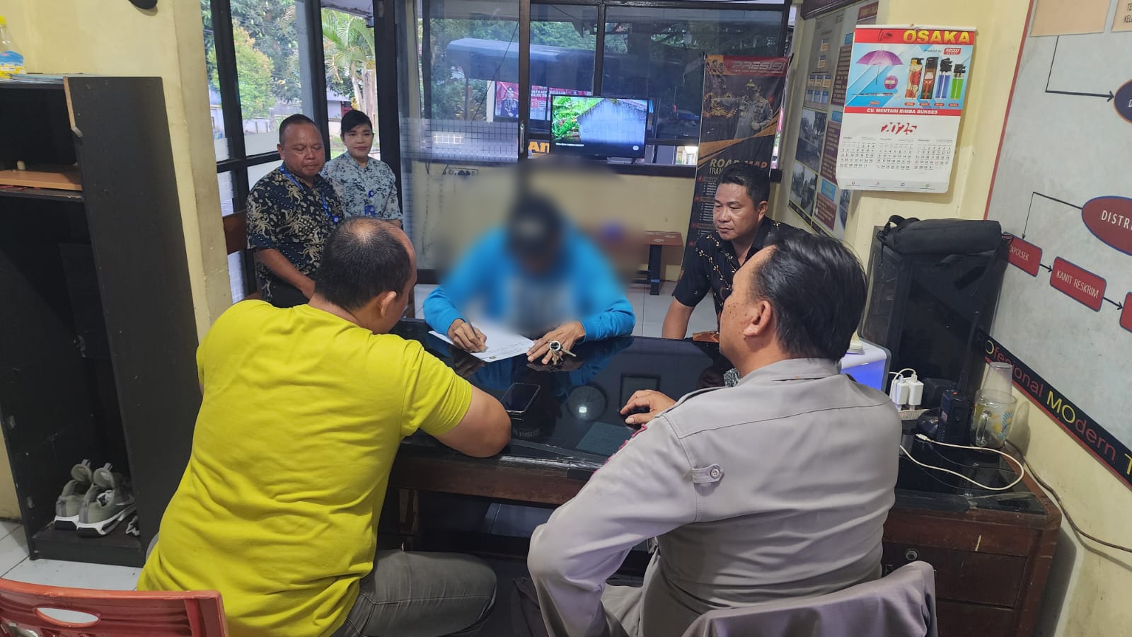 Pelaku pengancaman saat menulis surat pernyataan di hadapan petugas Polsek Ranowulu.(Dok Istimewa)