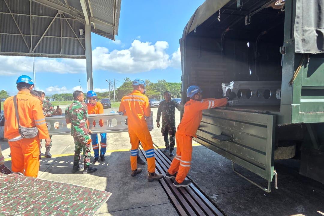 Personel PLN dan TNI Angkatan Darat mengangkut material tower Saluran Udara Tegangan Tinggi (SUTT) ke dalam truk di Landasan Udara Sultan Iskandar Muda, Aceh (30/11).