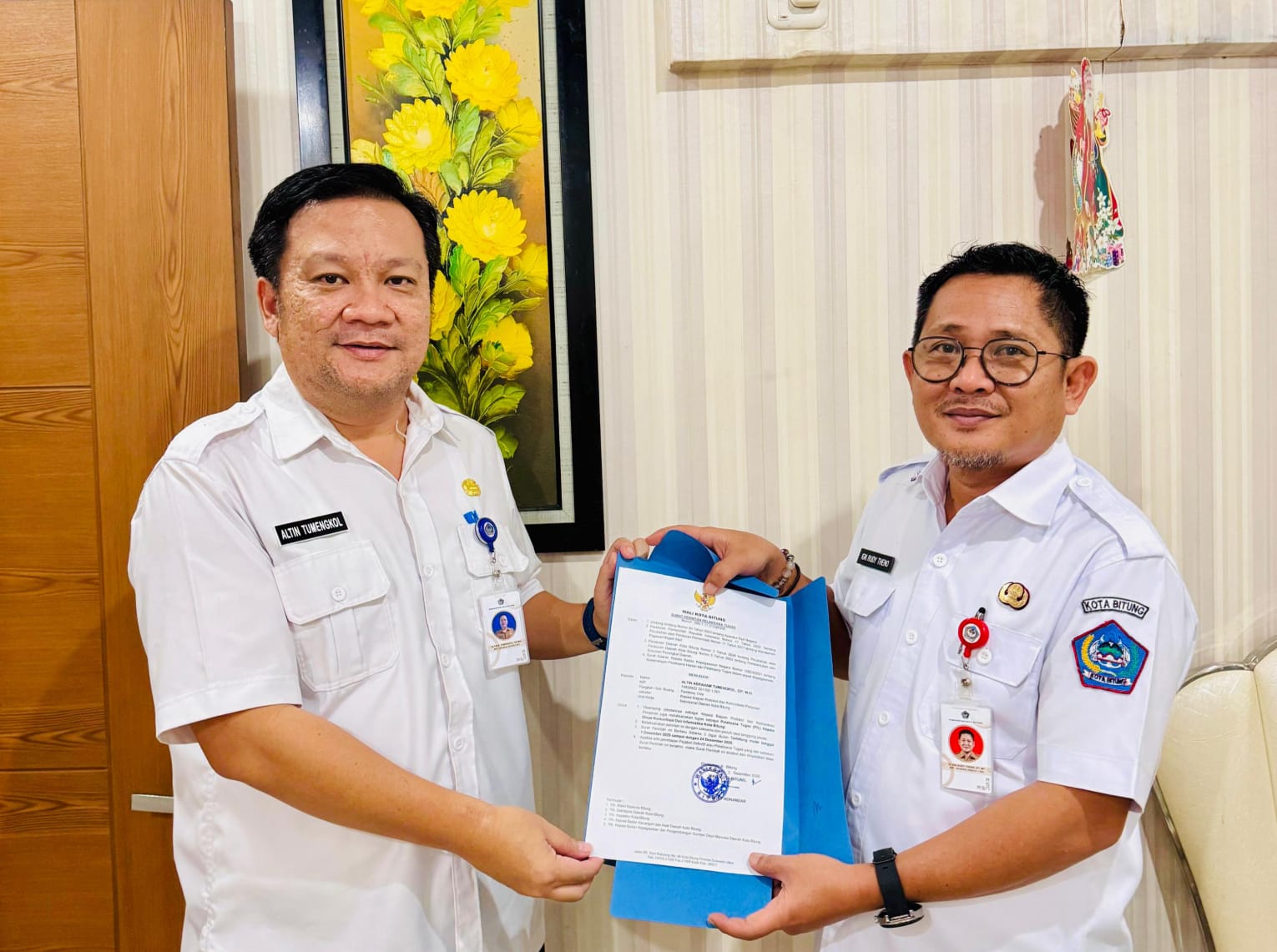 Sekkot Bitung Ign Rudy Theno menyerahkan SK Wali Kota Bitung kepada Altin Tumengkol sebagai Plt Kadis Kominfo.(Dok Istimewa)