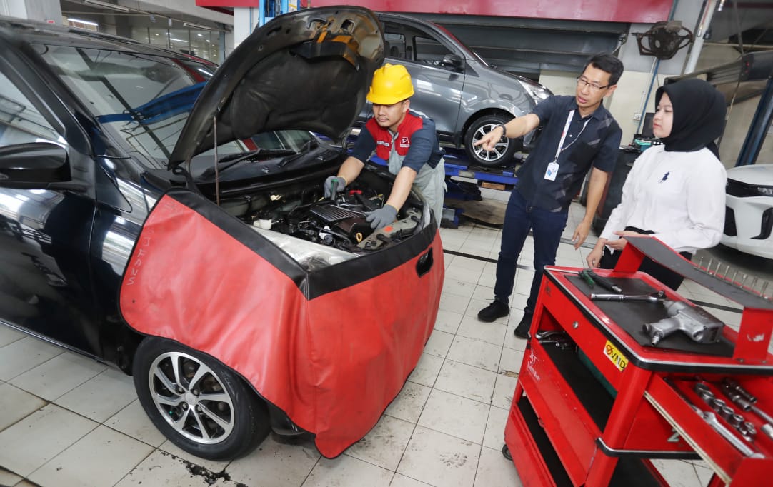 TERUS KEDEPANKAN SERVICE PRIMA: Marketing & Customer Relations Division Head PT AI DSO Tri Mulyono (tengah) memberikan penjelasan kepada customer yang melakukan service berkala di Bengkel.