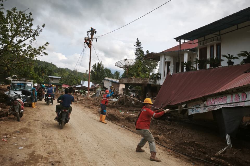 Petugas PLN melakukan penarikan kabel untuk disambungkan ke tiang-tiang listrik jaringan tegangan rendah (JTR) baru di Kabupaten Agam.