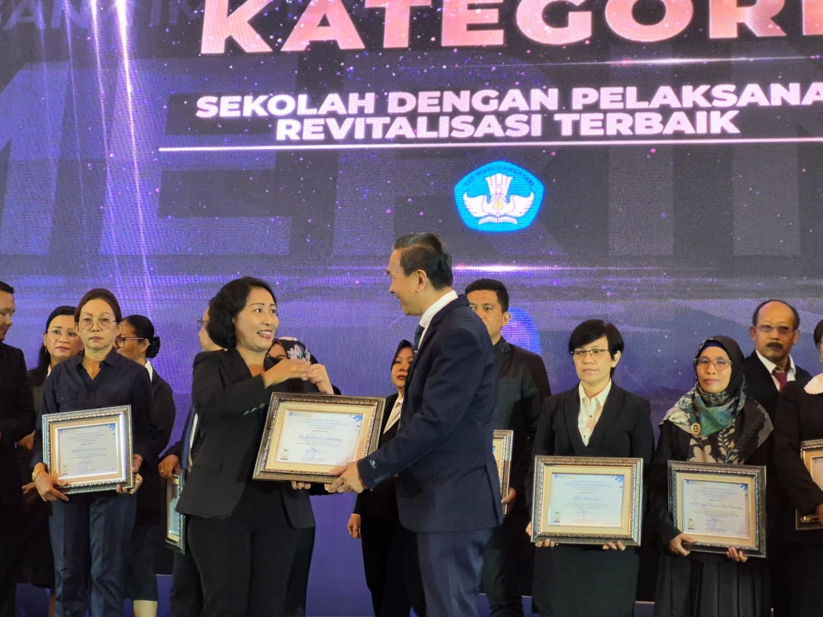 Kepala SD GMIM 1 Aertembaga, Ferlinda Salindeho saat menerima penghargaan dalam ajang Anugerah Mapalus Pendidikan Sulawesi Utara Tahun 2025.(Dok Istimewa)