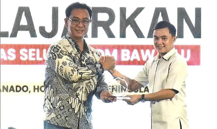Ketua Bawaslu Manado saat menerima penghargaan dalam kegiatan nasional yang digelar di Kota Manado, (17/12).