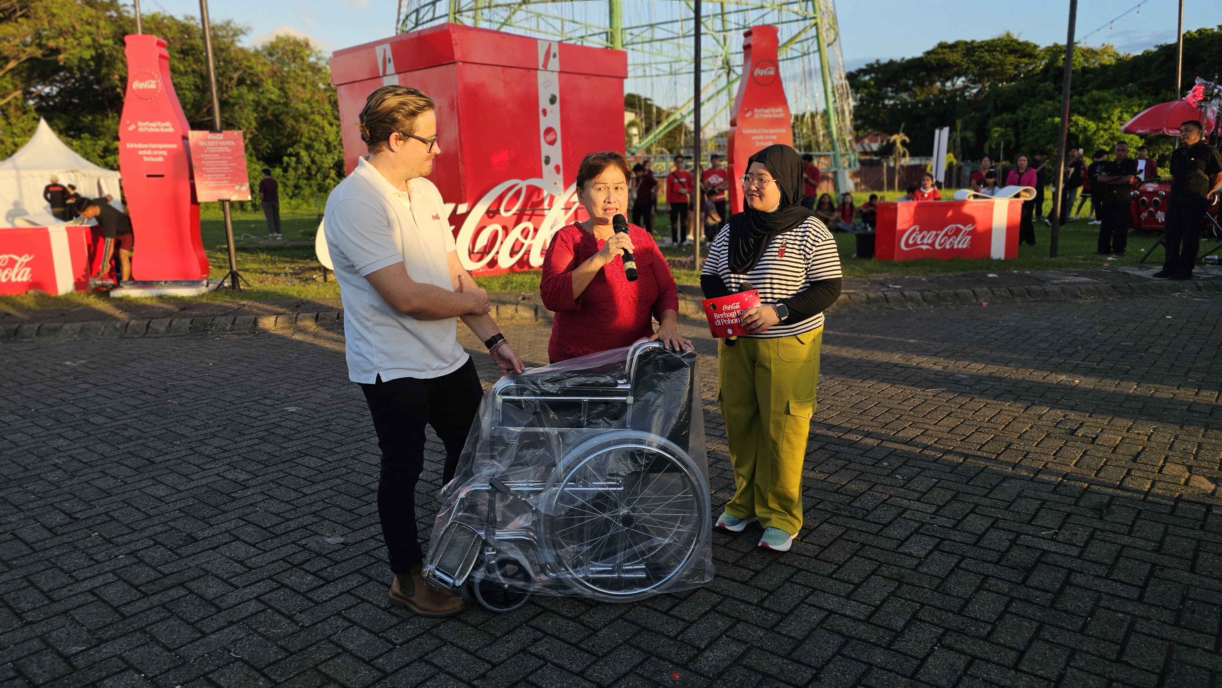 Grant Davidson selaku  Frontline Marketing Senior Director Coca-Cola Indonesia (baju putih) saat menyerahkan bantuan kursi roda pada masyarakat yang permintaannya terpilih.