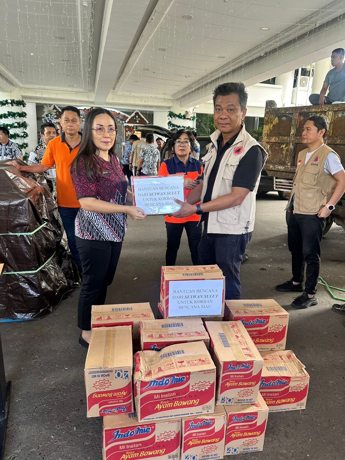Menli Menajang saat menyerahkan bantuan di posko di kantor gubernur.
