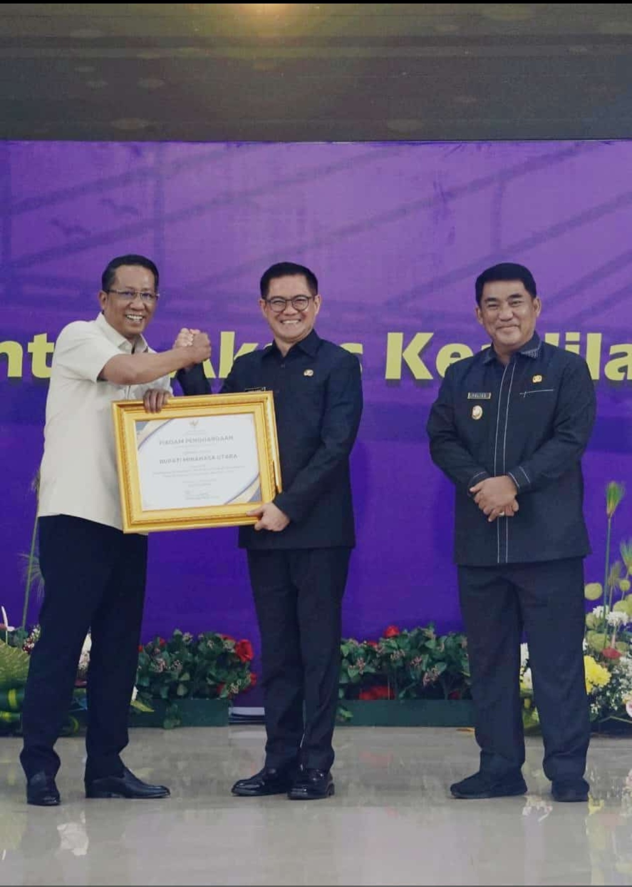 Bupati Minahasa Utara Joune Ganda saat menerima Piagam Penghargaan dari Menteri Hukum RI Supratman Andi Agtas disaksikan  Gubernur Sulawesi Utara Yulius Selvanus.  