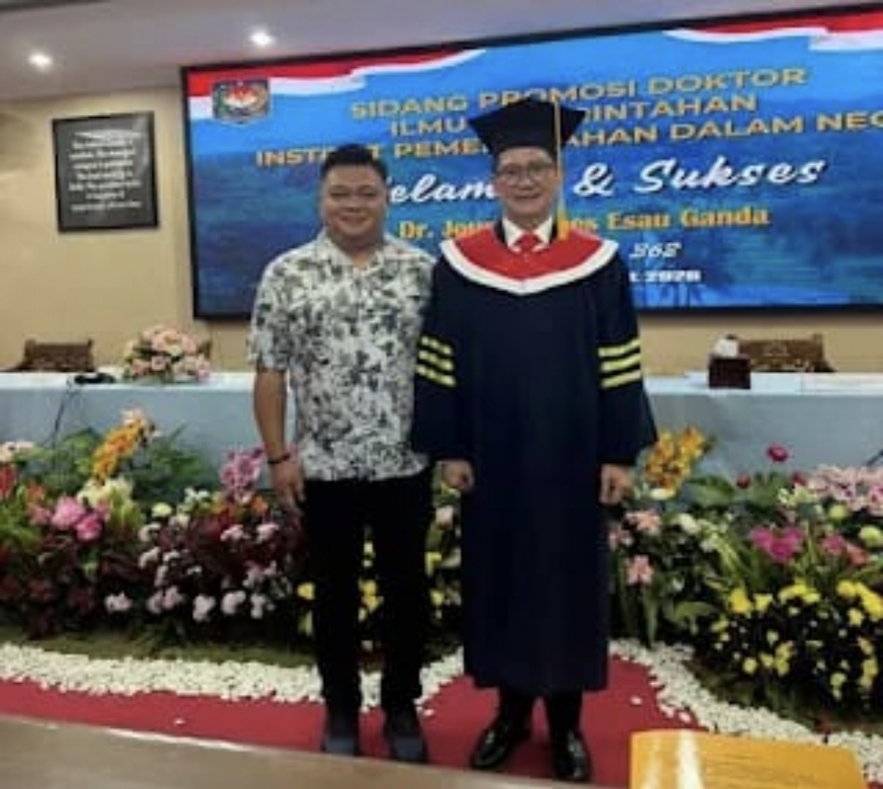 Apresiasi-Pengusaha Muda Minahasa Utara Eril Bolung saat swa foto bersama Bupati Minahasa Utara Joune Ganda usai ujian Gelar Doktor dari Institut Pemerintahan Dalam Negeri.  