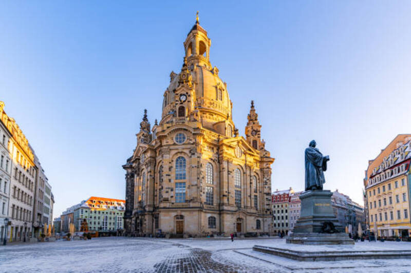 The Dresden Frauenkirche and the Luther Monument early in the winter morning light up by the morning sun.