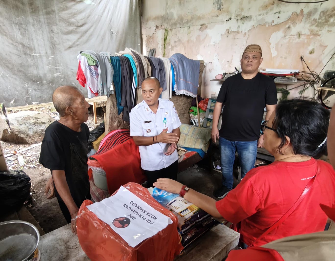 Ketua Komisi 3 DPRD Kota Manado bersama pengurus DPC PDIP Manado saat memberikan bantuan kepada seorang lansia warga Kelurahan Batukota, Rabu (11/3)