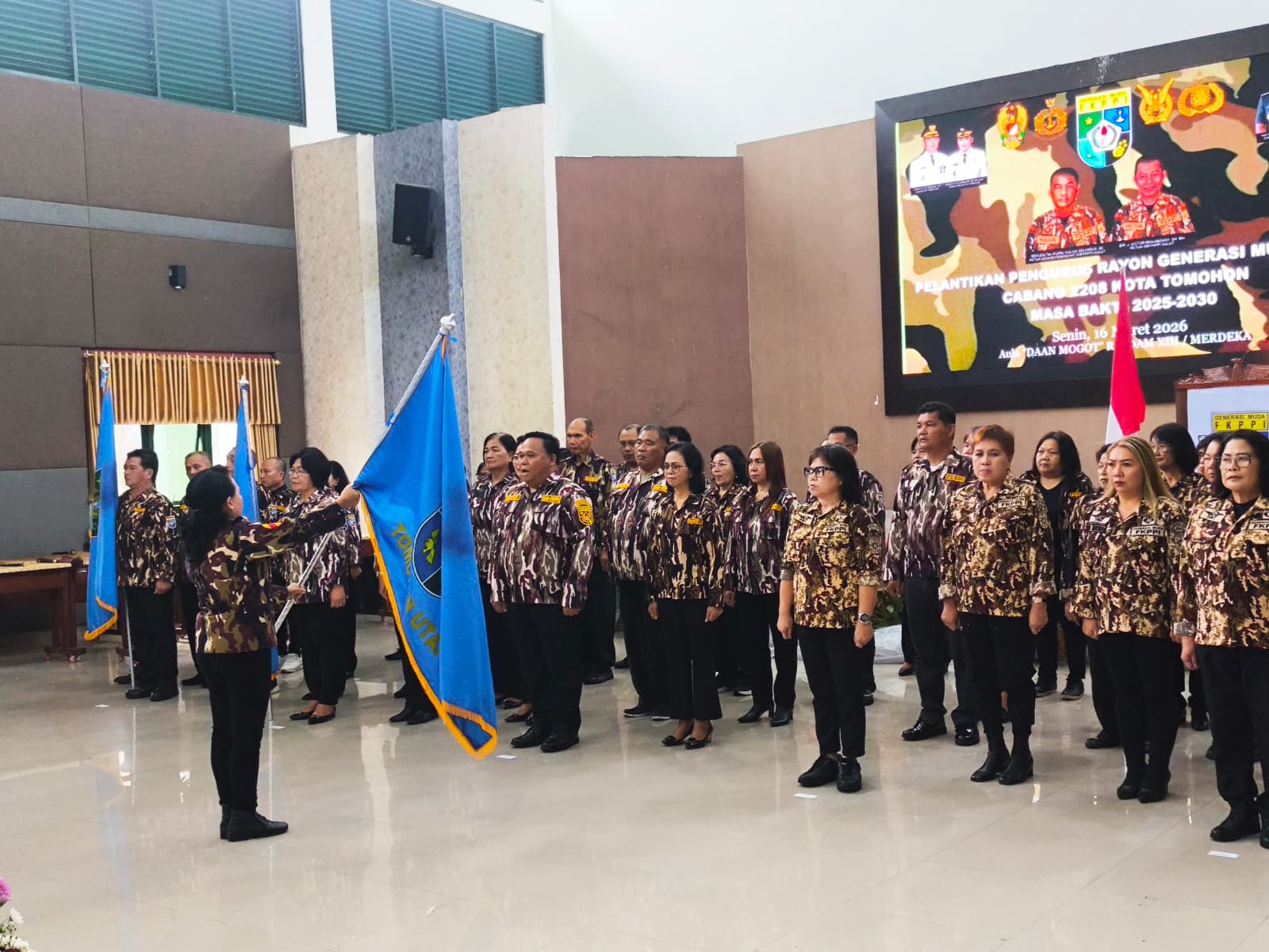 Ketua GM FKPPI Tomohon Mareyke Manengkey menyerahkan pataka kepada pengurus rayon yang dilantik. Dok Jul/MP