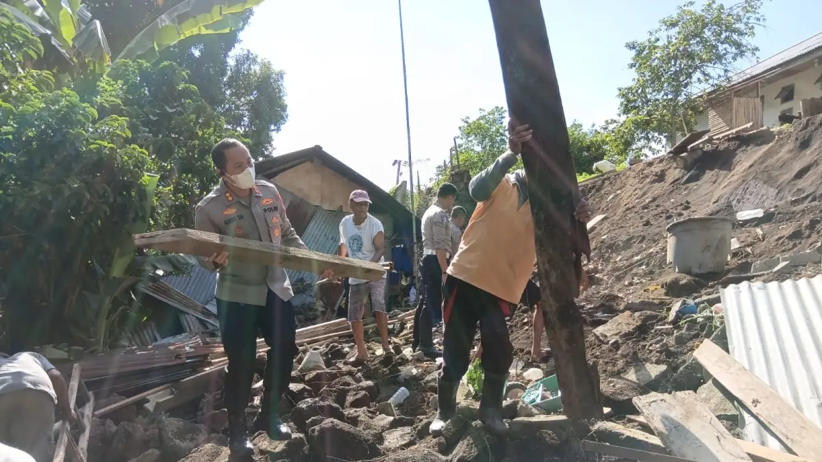 Kapolres Bitung AKBP Albert Zai turut serta membersihkan puing-puing tembok yang roboh pasca gempa bumi.(Dok Istimewa)
