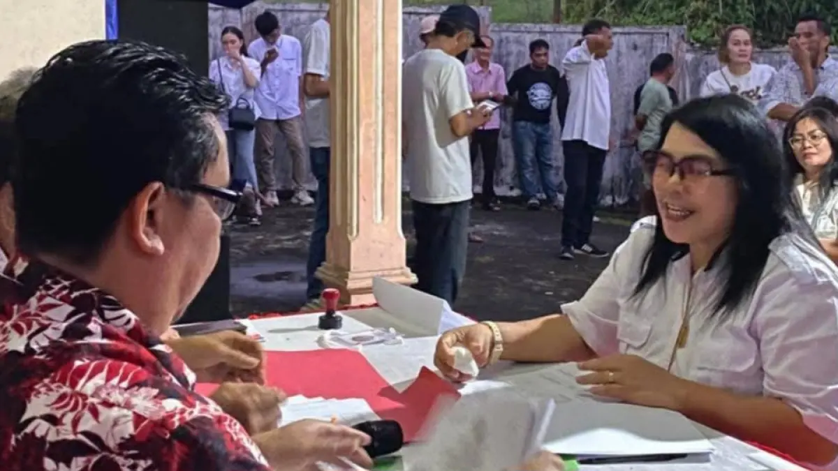 SIAP MELAYANI: Agustine Kojansow (kanan) menyatakan komitmennya untuk maju sebagai calon Hukum Tua Desa Pineleng Satu Timur, Kabupaten Minahasa, saat mendaftar pemilihan hukum tua, Jumat (17/04/26)