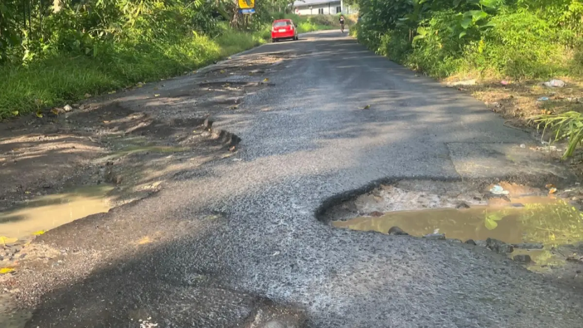 KONDISI MEMPRIHATINKAN: Sejumlah lubang besar dan genangan air tampak di ruas jalan penghubung Ratahan–Tombatu, tepatnya di akses masuk Perkebunan Lamet. Membahayakan pengguna jalan dan dikeluhkan warga karena belum diperbaiki.
