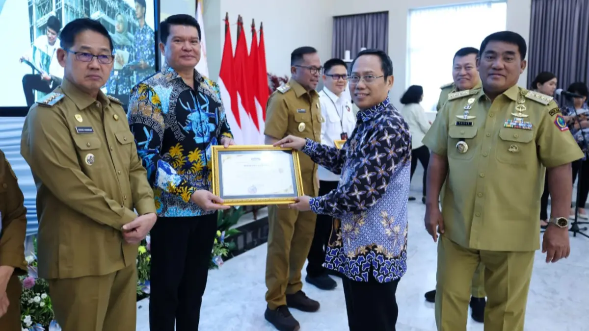 Direktur Perumda Air Minum Duasudara Bitung saat menerima penghargaan dari Kepala Perwakilan BPKP Sulut Heru Setiawan.(Dok Istimewa)